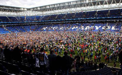 La afición del Espanyol festeja sobre el césped de Cornellà.