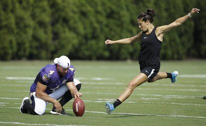 Sam Koch, de los Baltimore Ravens, sujeta el balón para que patee Carli Lloyd desde 55 yardas.