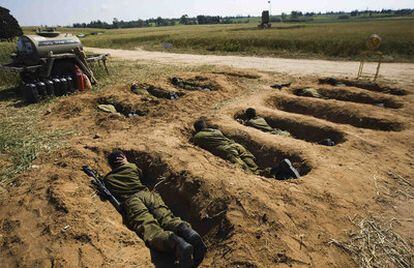 Soldados israelíes que gestionan el escudo antimisiles se ponen a cubierto en hoyos durante una alerta por lanzamiento de cohetes palestinos.