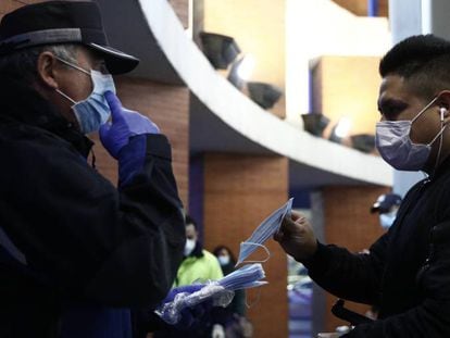 Agentes de policía reparten mascarillas en la estación de Atocha, en Madrid.