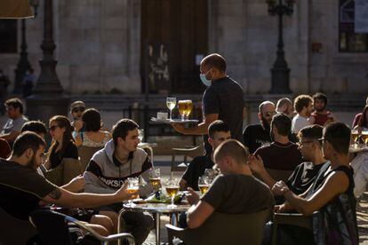 Un camarero atiende a los clientes de una terraza de un bar de Tarragona, este lunes.