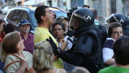 Un polic&iacute;a discute con un vecino que se opone al desalojo de una vivienda de la calle de Ofelia Nieto de Madrid, el pasado agosto.