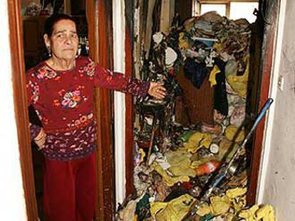 Una vecina de la casa incendiada muestra la basura acumulada.