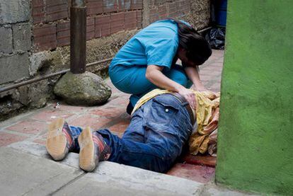 Una mujer llora en abril sobre el cadáver de su hermano, en una calle de Petarel.