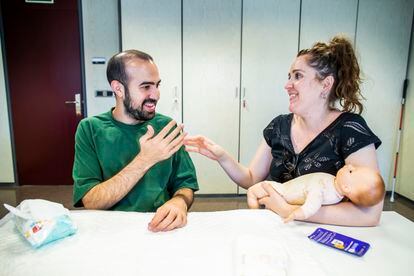 Javier García Pajares, persona con sordoceguera, y su pareja, Cristina Álvarez, en una clase para aprender a atender a un bebé, impartida en la Fundación ONCE.