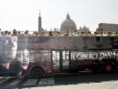 El anuncio de <i>El código Da Vinci</i> en un autobús <i>enmarca,</i> el viernes, la cúpula de San Pedro, en el Vaticano.
