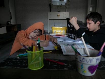 Dos niños estudiando en una casa de Madrid.