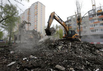 Una excavadora mueve los escombros de uno de los edificios demolidos.