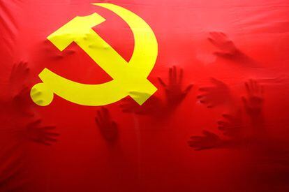 Un grupo de estudiantes de primaria se esconde debajo de una gran bandera del Partido Comunista de China, en un acto para celebrar el 90 aniversario de la formación. Fundado en 1921, es hoy, con más de cerca de 80 millones de afiliados, la organización política con más miembros.