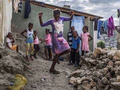 Una niña del barrio de Jalousie baila entre las chabolas ante la mirada divertida de sus amigos.