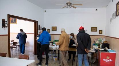 Una cocinera sirve comida en el comedor de Cáritas en Jaén, en 2022.