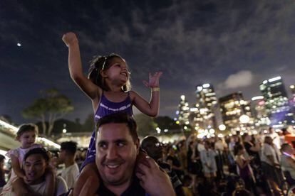 Diverses famílies gaudeixen dels focs artificials a Sidney tres hores abans del canvi d'any.