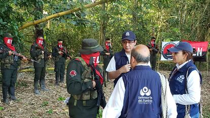 Funcionarios de la Defensoría del Pueblo hablan con guerrilleros del ELN, durante la liberación de varios soldados y un policía en zona rural de Arauca, el 17 de agosto de 2022.