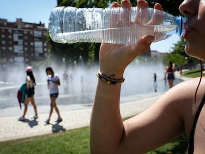 Una mujer bebe agua embotellada en el parque Madrid Río.