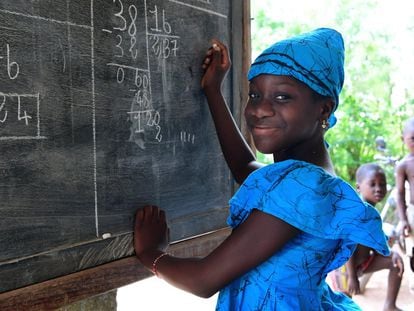 Fatimata Bagayogo (11 años) estudia en casa durante la pandemia, en Odienné, Costa de Marfil. Como las escuelas están cerradas, ella asiste a clases por televisión y practica matemáticas en una pizarra.