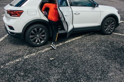 Un niño sube a un coche tipo SUV que sobresale de una plaza de aparcamiento en las afueras de Santiago de Compostela, este jueves.