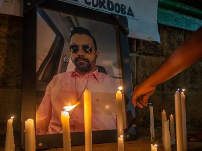 Una persona coloca una vela en honor de periodista asesinado Rafael Moreno.