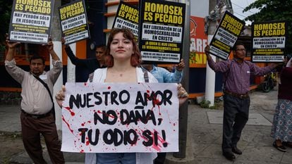 Miembros religiosos sostienen pancartas durante desfile del orgullo LGBTQIA+ en San Salvador, el 24 de junio de 2023.