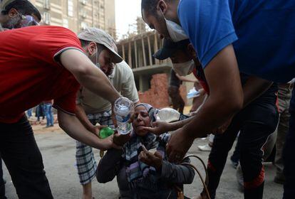 Una mujer es atendida tras haber estado expuesta al gas lacrimógeno lanzado por la policía en El Cairo.