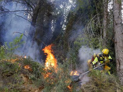 Un bombero trabaja para el extinción del incendio forestal en la localidad valenciana de Ador, este sábado.