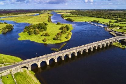 En las praderas de un verde intenso pacen a su aire las vacas y las ovejas, regalando una mirada apática a los barcos que pasan junto a ellas. Una travesía de varias jornadas por este río irlandés es, ante todo, variada: después de horas atravesando unos bellísimos parajes deshabitados, un pueblecito brinda de repente la oportunidad de hacer una pausa o visitar alguna iglesia medieval. Antaño era sobre todo la cervecera Guinness quien utilizaba el río y los muchos canales que de él salen para distribuir sus barriles. Hoy, el plácido <a href="https://www.ireland.com/de-de/aktivitaeten/wassersport/" target="_blank">Shannon</a> se ha convertido en un paraíso para gente ávida de reposo y para amantes de la naturaleza.