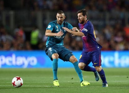 El jugador del Barcelona, Lionel Messi, disputa el esferico con el jugador del Real Madrid, Karim Benzema.