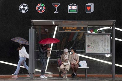 Varias mujeres se protegen de la lluvia en una parada de autobús, el pasado miércoles en Murcia.