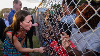 El príncipe Guillermo y su esposa Kate saludan a una multitud de niños negros agolpados en una alambrada en Kingston (Jamaica), en marzo.