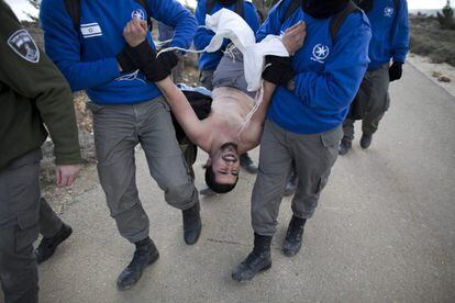 Policías israelíes detienen un hombre durante la evacuación del asentamiento judío de Amona.