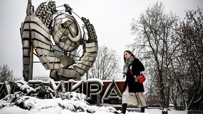 Una mujer pasa junto a un emblema estatal de la URSS en un parque de esculturas de historia moderna en Moscú, en diciembre de 2021.