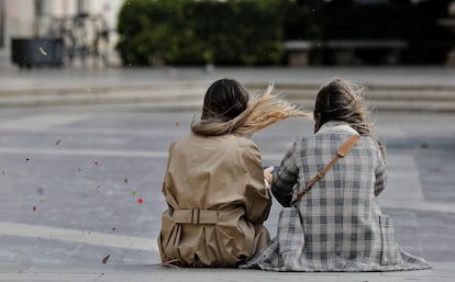 Dos jóvenes, este mediodía, en la plaza de la Virgen de Valencia.