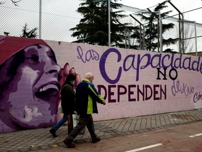 Dos personas pasan por el mural feminista en el polideportivo municipal de la Concepción en el distrito de Ciudad Lineal.
