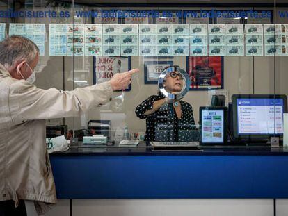 Un hombre compra en administración de lotería de Valencia, este martes.