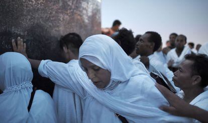 Una mujer toca las piedras del monte Arafat mientras reza como parte de su peregrinación.