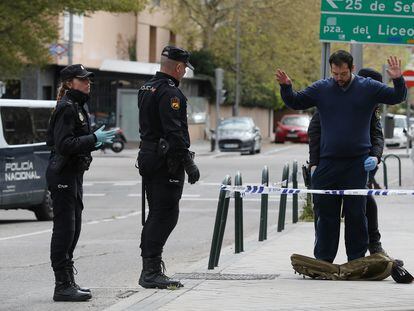 Varios miembros de la Policía Nacional cachean a una persona durante el confinamiento por la pandemia de coronavirus en Madrid.