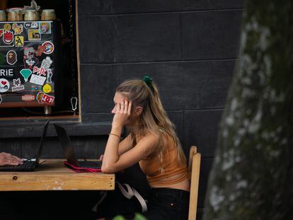 Una joven extranjera utiliza su computadora portatil en un café en la calle de de Orizaba, en Ciudad de México, el 11 de noviembre de 2022.