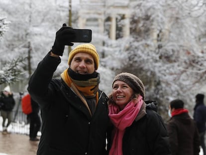 Dos personas se toman una foto en el Retiro, en Madrid, durante la nevada.