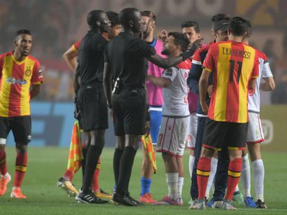 Jugadores de ambos equipos protestan a los árbitros.