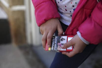 Natasha, de ocho años, sujeta un paquete de tabaco .