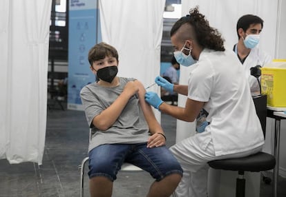 Un adolescente recibe su primera dosis contra la covid-19 en el centro de vacunación de la Fira de Barcelona