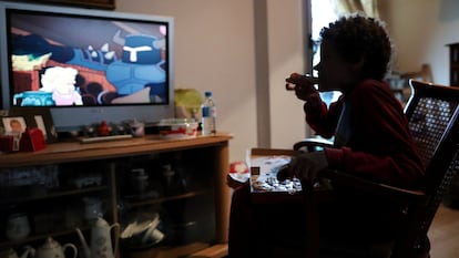Un niño come un trozo de pizza mientras ve la televisión en su casa en marzo del pasado año en Madrid.