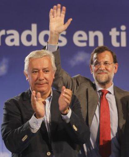 Mariano Rajoy (derecha) y Javier Arenas saludan al público en el mitin de Sevilla.