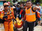 Rescue workers carry a body bag containing the remains of a victim of the tsunami in Pandeglang