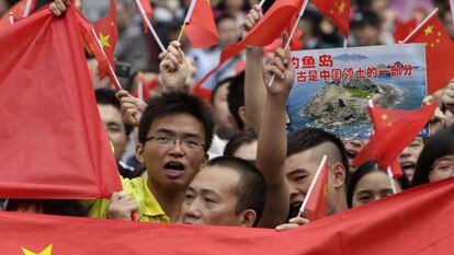 Manifestantes enarbolan banderas chinas para reclamar la soberan&iacute;a de Pek&iacute;n sobre las islas Diaoyu, que Jap&oacute;n considera suyas.