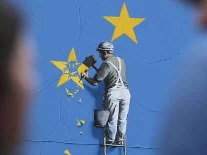 Una persona mira un mural de Banksy