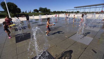 Unos ni&ntilde;os se refrescan en las fuentes de un parque de Madrid. 