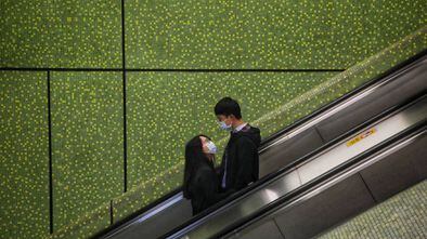 Una pareja vive su amor en tiempos ce coronovirus en un centro comercial de Hong Kong.