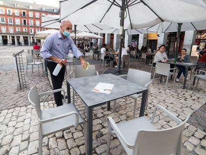 Un camarero desinfecta una mesa en una terraza madrileña, el pasado 25 de mayo.