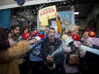 Varias personas celebran el Gordo del sorteo extraordinario de Navidad de la Lotería Nacional que ha recaído en el nº 88.008, este viernes en la Administración de la calle Monforte de Lemos de Madrid.