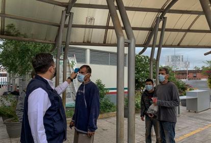Un funcionario estatal toma la temperatura a un grupo de migrantes deportados a su llegada a Reynosa. 